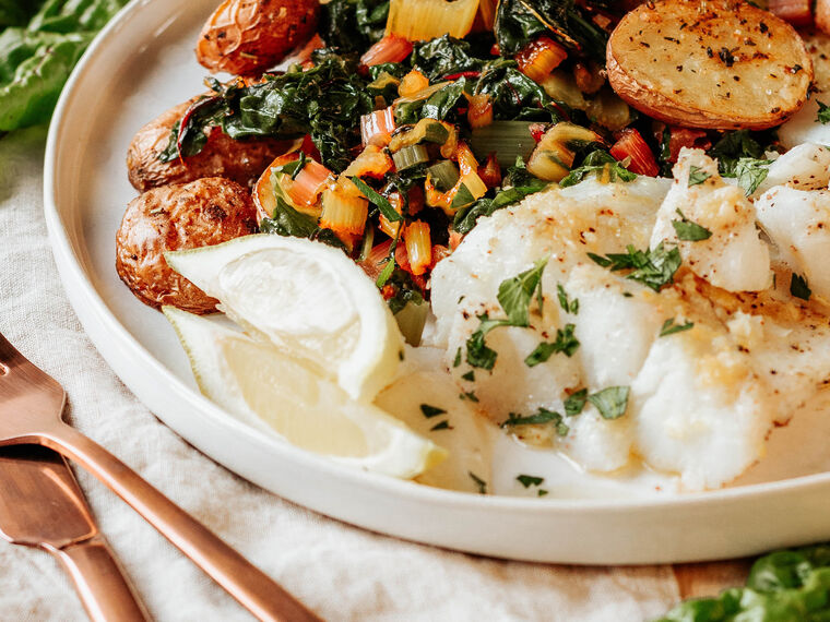 Pan roasted wild caught fish with a wedge of lemon and a side of potatoes